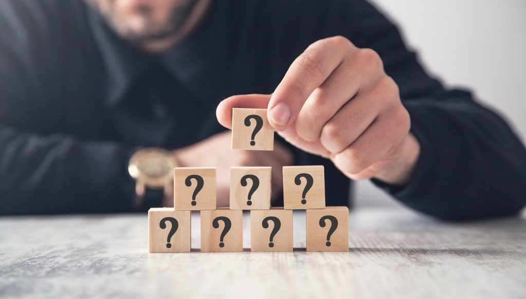 Man stacking cubes with question mark