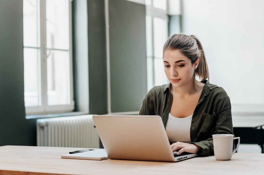 Woman sitting at a table and working on a laptop