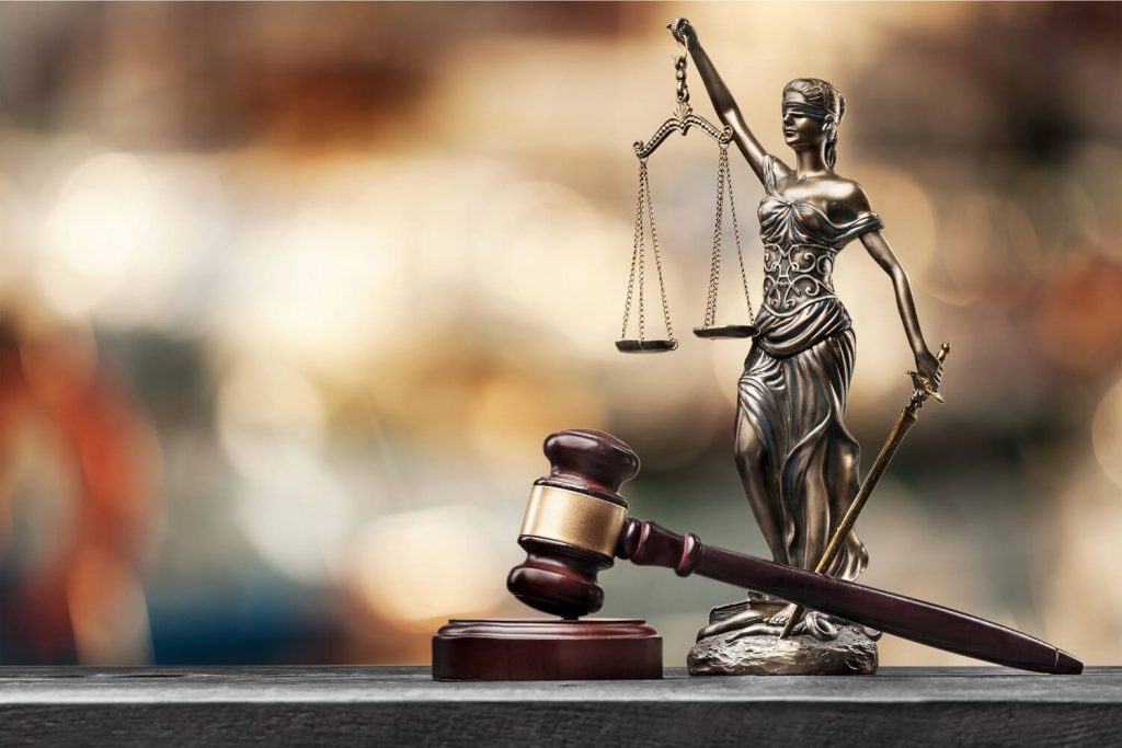 The goddess of justice and the gavel of justice lie on the table